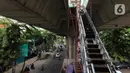 Pekerja menyelesaikan pembangunan jembatan penyeberangan orang (skywalk) di kawasan Kebayoran Lama, Jakarta, Rabu (2/11/2022). Pengerjaan skywalk sepanjang 500 meter dengan desain cahaya artistik dan dilengkapi fasilitas lift nantinya mengintegrasikan Stasiun Kebayoran dengan Halte Transjakarta Koridor 8 dan Koridor 13. (Liputan6.com/Herman Zakharia)