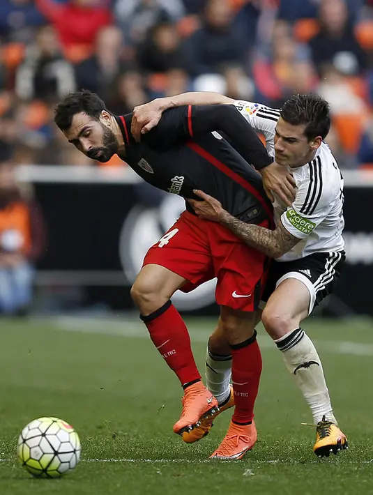 3. Gelandang Valencia, Santi Mina, berebut bola dengan bek Athletic, Mikel Balenziaga, pada laga La Liga Spanyol di Stadion Mestalla, Minggu (28/2/2016). Valencia takluk 0-3 dari Athletic. (EPA/Kai Foersterling)