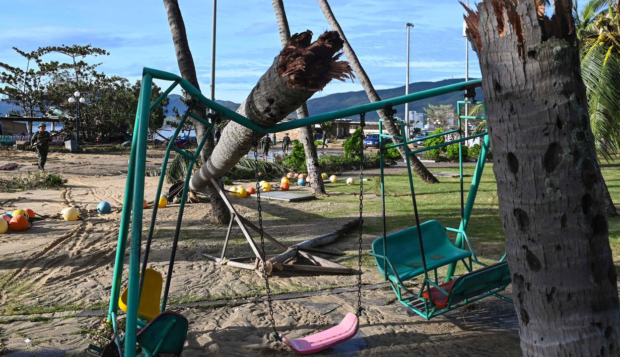 Sebagian batang pohon yang patah terlihat di atas ayunan di kawasan pesisir Quy Nhon, Provinsi Gia Lai, Vietnam Tengah, pada Jumat 7 November 2025, setelah topan Kalmaegi melanda wilayah tersebut. Topan Kalmaegi menerjang kawasan pesisir Vietnam tengah pada Kamis (6/11/2025) malam. (NHAC NGUYEN/AFP)