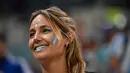 Seorang fans wanita Argentina tersenyum di tribun menjelang pertandingan semifinal Piala Dunia Qatar 2022 antara Argentina dan Kroasia di Stadion Lusail di Lusail, utara Doha, Rabu (14/12/2022). (AFP/ Anne-Christine Poujoulat)