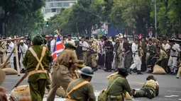 Anggota Komunitas Roode Brug Soerabaia dan Reenactor Indonesia berpartisipasi dalam reka ulang Pertempuran Surabaya, pada Minggu 2 November 2025. Mereka menampilkan beragam atraksi dan teatrikal memukau, dengan kostum unik yang merepresentasikan semangat juang rakyat tempo dulu. (Juni KRISWANTO/AFP)