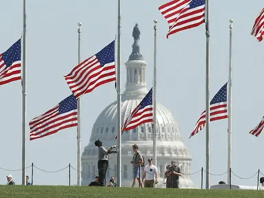 Pemandangan bendera setengah tiang di belakang gedung Capitol di Washington, DC. AS (2/10). Presiden Donald Trump memerintahkan untuk menurunkan bendera setengah tiang menyusul penembakan di Las Vegas. (Mark Wilson/Getty Images/AFP)