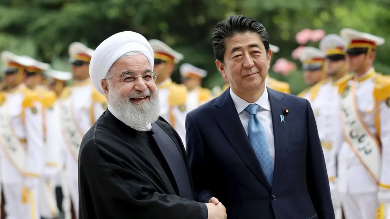 Presiden Iran Hassan Rouhani (kiri) berjabat tangan dengan Perdana Menteri Jepang Shinzo Abe (AP/Ebrahim Noroozi)