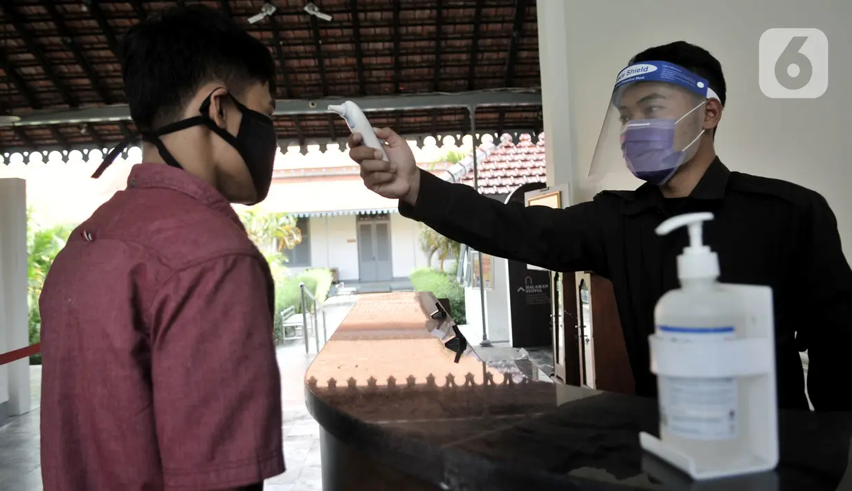 Petugas memeriksa suhu tubuh salah seorang pekerja saat hendak memasuki Museum Kebangkitan Nasional, Jakarta, Senin (8/6/2020). Pengelola menyiapkan standar protokol kesehatan jelang dibuka kembali untuk umum saat masa PSBB Transisi guna memutus penyebaran Covid-19. (merdeka.com/Iqbal S Nugroho)