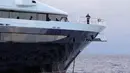 Petugas Polda Bali dengan sejumlah penyidik FBI berada di atas kapal pesiar mewah (yacht) bernama Equanimity di Teluk Benoa, Rabu (28/2). Kapal ini diproduksi Oceanco asal Belanda dan dikirim kepada pemesannya pada tahun 2014 lalu. (AP/Ambros Boli Berani)