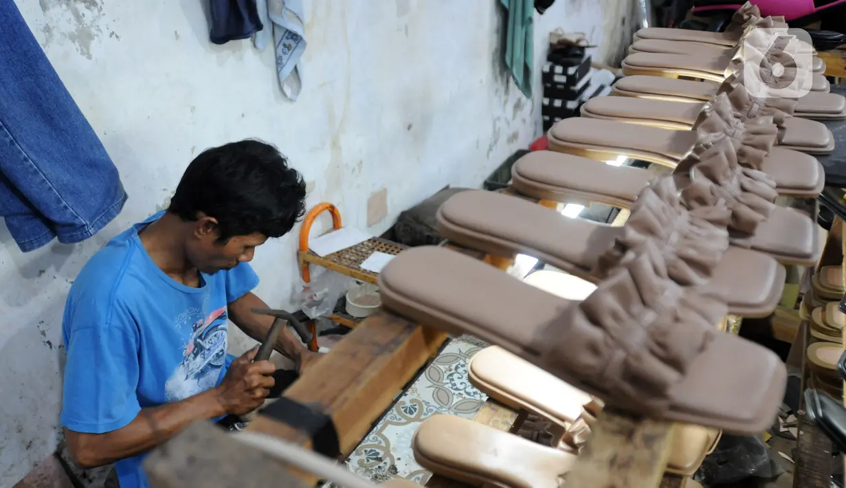 Perajin alas kaki menyelesaikan pembuatan sandal di kawasan Bojongsari, Depok, Jawa Barat, Selasa (22/2/2022). UMKM alas kaki kembali tumbuh menggeliat setelah sempat goyang pada awal masa pandemi yang menyebabkan sejumlah UMKM tutup tidak beroperasi. (merdeka.com/Arie Basuki)