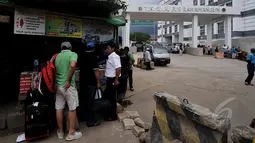 Calon penumpang menunggu bus di depan bangunan baru terminal Rawamangun yang sedang direvitalisasi, Jakarta, Kamis (12/3/2015). Revitalisasi terminal Rawamangun ditargetkan selesai Desember 2014, hingga kini belum beroperasi. (Liputan6.com/Johan Tallo)