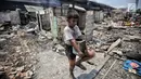Seorang anak mengais sisa sisa barang paska kebakaran di permukiman kumuh di RW 02 Kampung Walang, Lodan Raya, Jakarta, Minggu (25/8). Sebanyak 420 jiwa saat ini mengungsi pasca-kebakaran, di sebuah tenda darurat. (Liputan6.com/Faizal Fanani)