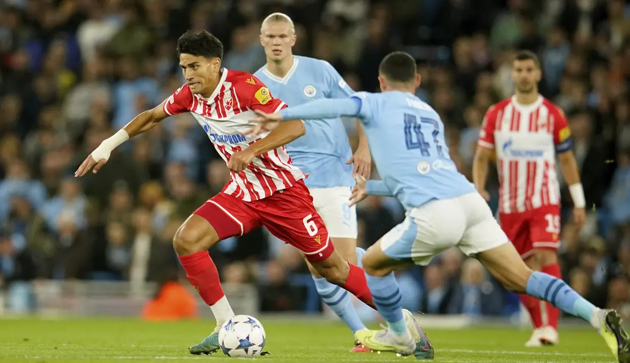 Gelandang Red Star Belgrade Marko Stamenic mencoba mengarahkan bola melewati gelandang Manchester City Phil Foden pada laga matchday 1 Grup G Liga Champions 2023/2024 di Etihad Stadium, Rabu (20/9/2023) dini hari WIB. (AP Photo/Dave Thompson)