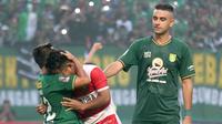 Pemain Madura United, Andik Vermansah, dipeluk Rendi Irwan saat ikut ambil bagian dalam momen Song of Pride yang dinyanyikan pendukung Persebaya Surabaya usai laga leg pertama semifinal Piala Presiden 2019 di Stadion Gelora Bung Tomo, Surabaya, Rabu (3/4/2019). (Bola.com/Aditya Wany)