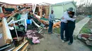 Phyllis Evans mendapat pelukan dari Harvey Payne setelah melihat kondisi rumahnya yang dihantam tornado di Holly Springs, Mississipi, Kamis (24/12). Badai tornado menerjang wilayah Amerika Serikat bagian selatan dan menewaskan 11 orang.  (REUTERS)