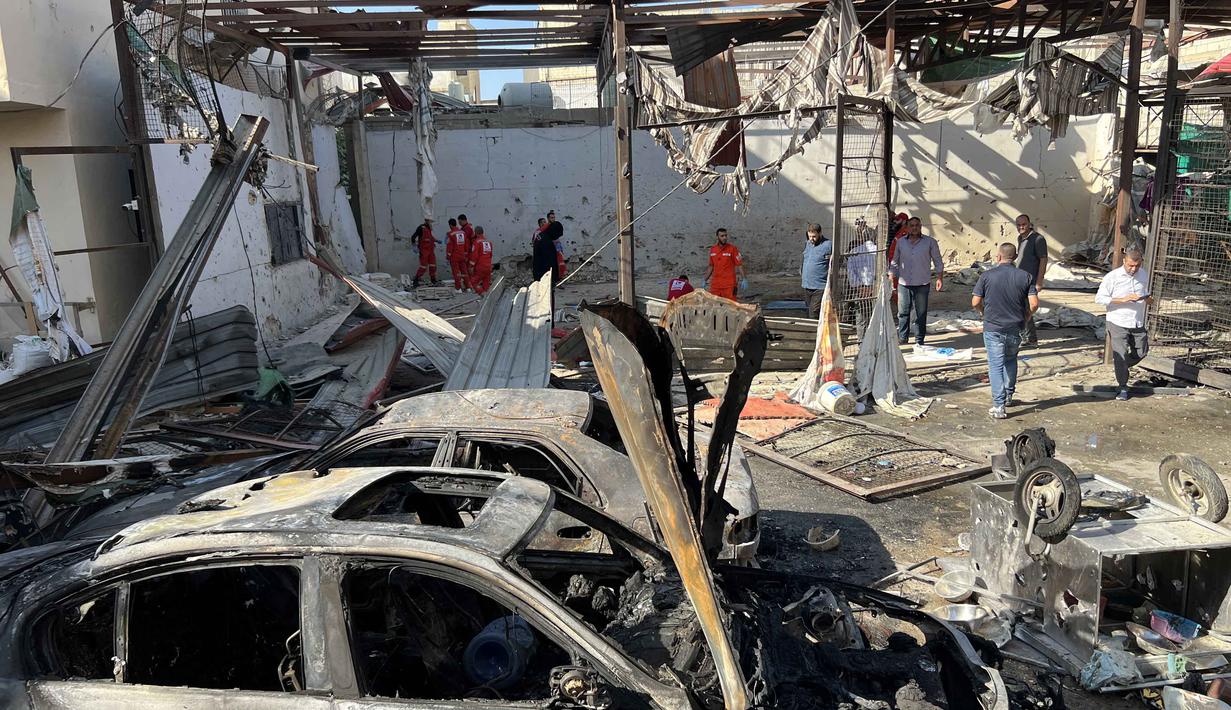 Serangan menargetkan area yang padat penduduk di dalam Ain al-Hilweh, kamp pengungsi Palestina terbesar di Lebanon, dekat kota Sidon. Tampak dalam foto, petugas medis memeriksa kondisi puing-puing mobil di kamp pengungsi Palestina Ain al-Hilweh, dekat Sidon di selatan Lebanon, pada Rabu 19 November 2025. (Mahmoud ZAYYAT/AFP)