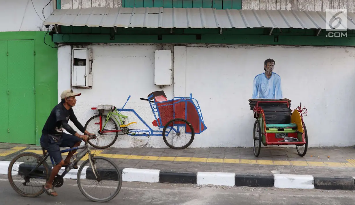 Pengendara sepeda melintas di depan Kampung Tematik Sketsa di kawasan Penjaringan, Jakarta Utara, Rabu (1/7). Sketsa-sketsa yang menghiasi kawasan tersebut dibuat dalam rangka menyambut Asian Games XVIII Tahun 2018. (Liputan6.com/Immanuel Antonius)