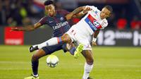 Pemain PSG, Presnel Kimpembe (kiri) berebut bola dengan pemain Lyon, Memphis Depay pada lanjutan Ligue 1 Prancis di Parc des Princes stadium, Paris, (17/9/2017). PSG menang 2-0. (AP/Francois Mori)