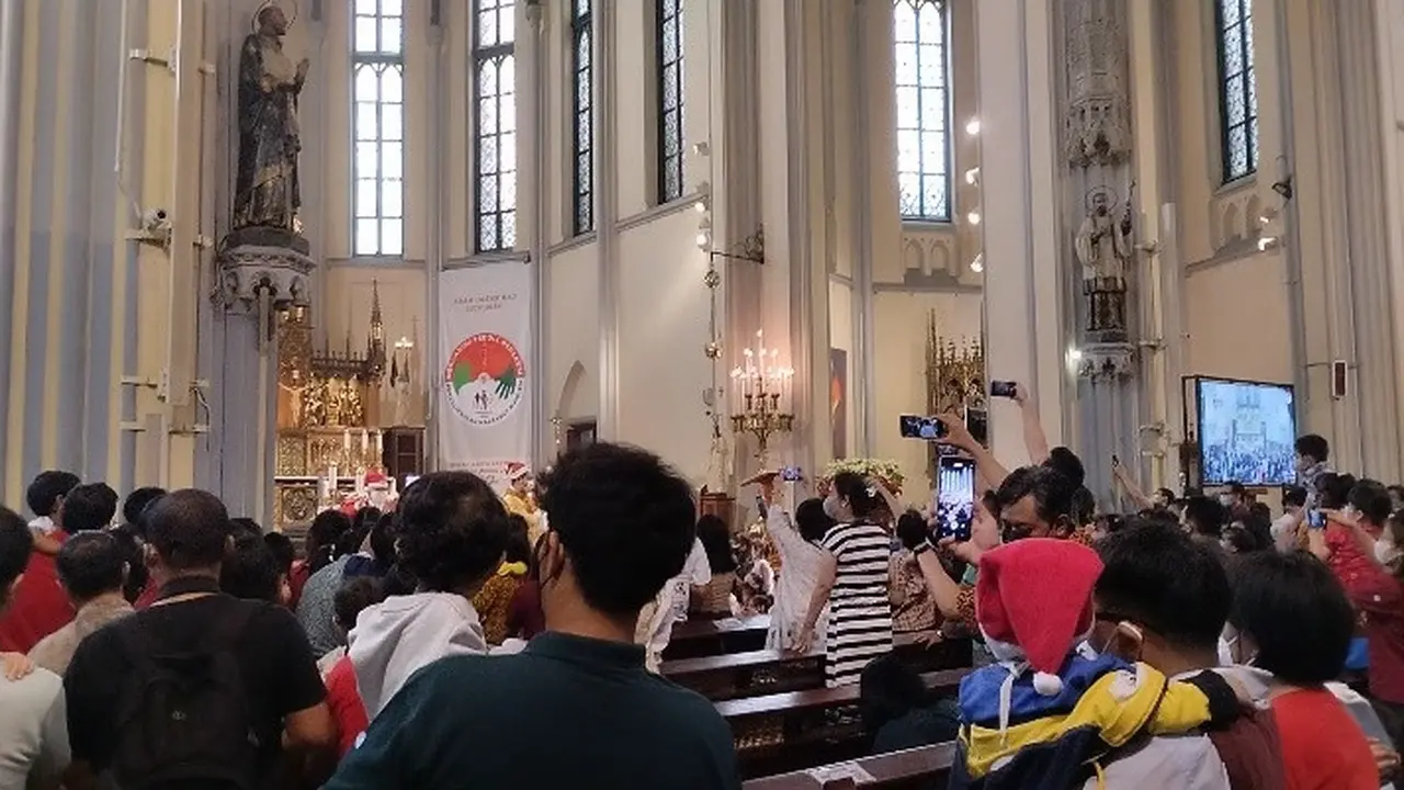 Ribuan jemaat mengikuti Misa Keluarga di Gereja Katedral, Jakarta Pusat, siang ini, Minggu (25/12/2022).