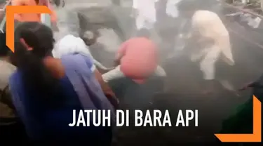 Seorang wanita menjalani ritual kuno di India. Di pertengahan jalan wanita tersebut jatuh di bara api. Ritual ini menandai dimulainya festival Holi.