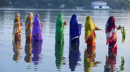 Sejumlah perempuan Hindu India membawa sesajen ketika berdoa pada matahari di tepi Danau Hussain Sagar di Hyderabad saat Festival Chhath untuk memuja dewa matahari, Selasa (17/11). (AFP PHOTO/NOAH Seelam)