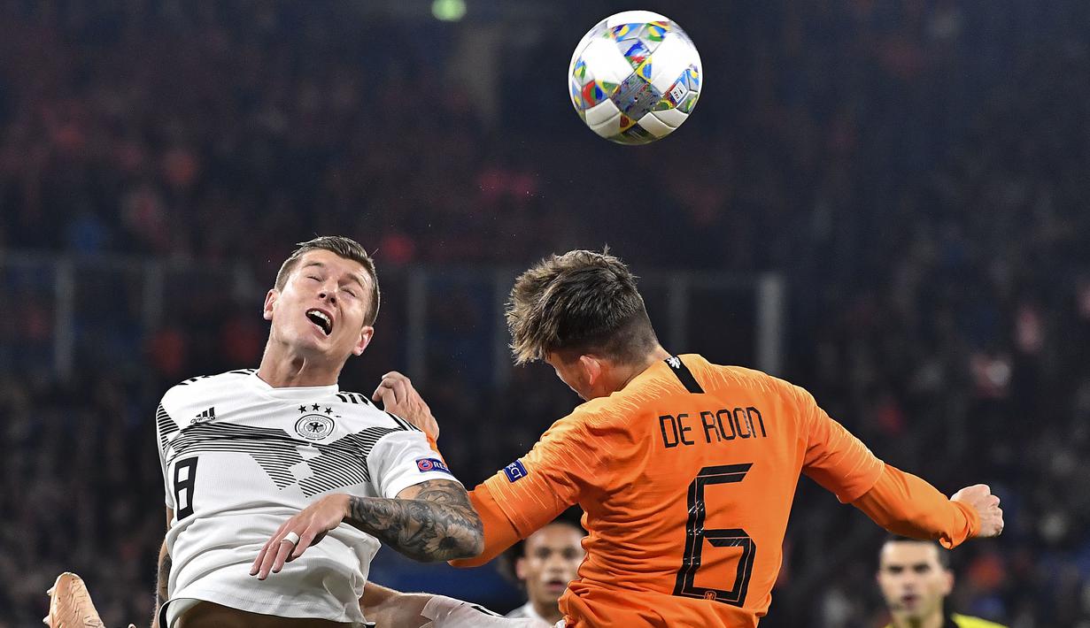Pemain Belanda, Marten de Roon, duel udara dengan gelandang Jerman, Toni Kroos, pada laga UEFA Nations League di Veltins Arena, Gelsenkirchen, Senin (19/11/2018). Kedua tim bermain imbang 2-2. (AP/Martin Meissner)