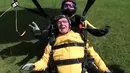 Verdun Hayes mendarat setelah skydiving di Devon, Inggris, Minggu (14/5). Kakek 101 tahun itu memecahkan rekor dunia untuk skydiver tandem tertua setelah melompat dari ketinggian 15.000 kaki bersama dengan empat generasi keluarganya. (Skydive.buzz via AP)