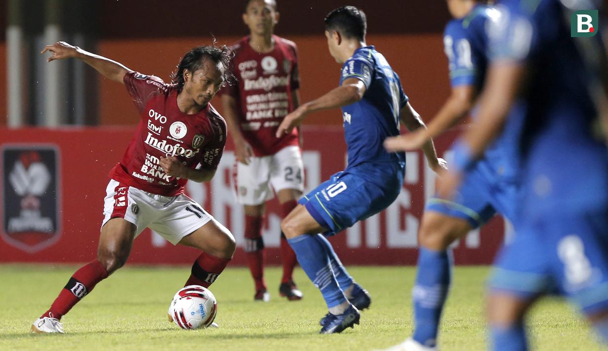 Gelandang Bali United, Hariono (kiri) berusaha melewati hadangan mantan rekannya di Persib Bandung, gelandang Esteban Vizcarra dalam laga Grup D Piala Menpora 2021 di Stadion Maguwoharjo, Sleman. Rabu (24/3/2021). Bali United bermain Imbang 1-1 dengan Persib. (Bola.com/Arief Bagus)