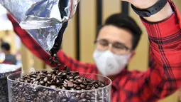Seorang staf menuang biji kopi ke dalam mesin pembuat kopi di stan jaringan restoran cepat saji asal Kanada, Tim Hortons, di area ekshibisi Produk Makanan dan Pertanian Pameran Impor Internasional China (China International Import Expo/CIIE) ketiga di Shanghai, China timur (5/11/2020). (Xinhua/Chen