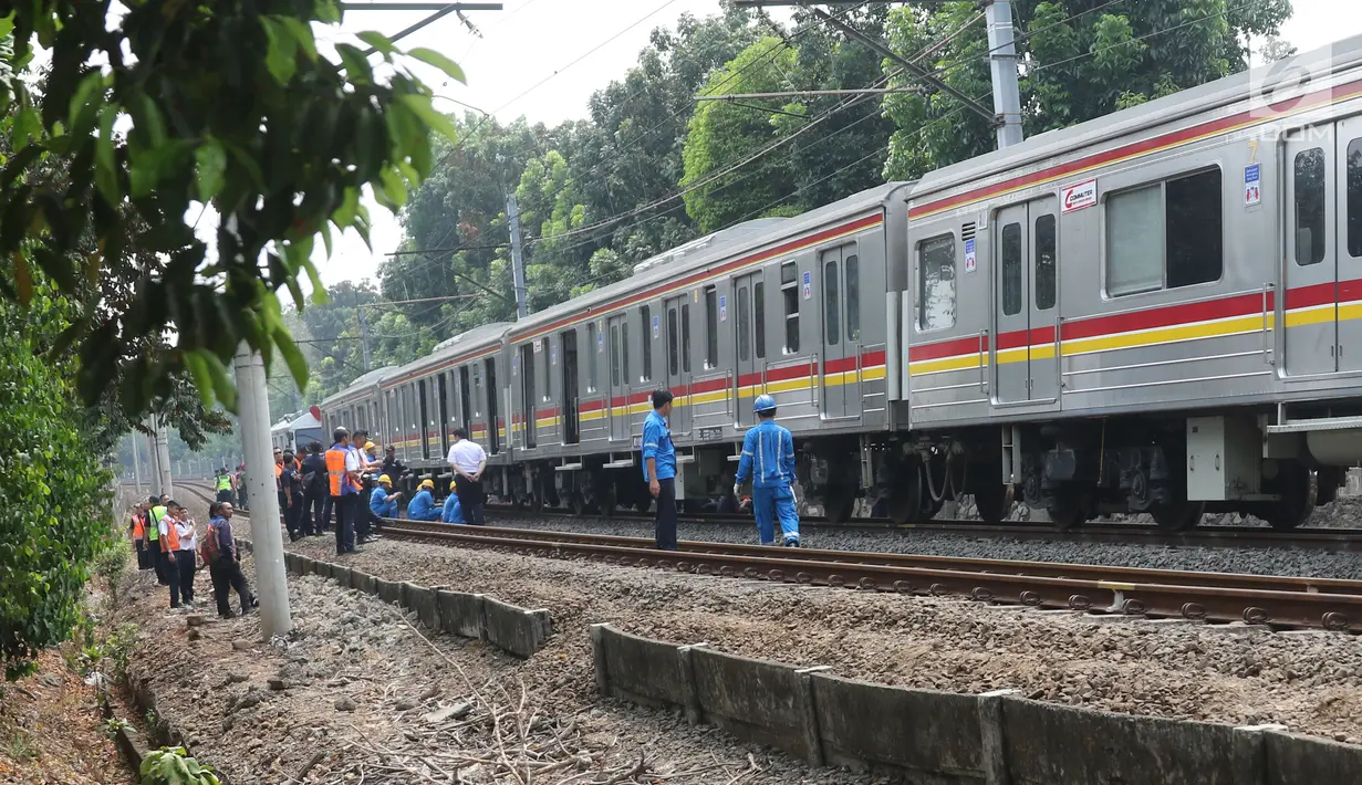 Sejumlah petugas KAI memeriksa keadaan kereta yang anjlok di dekat Stasiun Palmerah, Jakarta, Sabtu (13/10). Petugas masih menyelidiki penyebab anjloknya kereta tersebut. (Liputan6.com/Herman Zakharia)