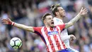 Gelandang Real Madrid, Gareth Bale, berebut bola dengan gelandang Atletico Madrid, Saul Niguez, pada laga La Liga Spanyol di Stadion Santiago Bernabeu, Madrid, Minggu (8/4/2018). Kedua klub bermain imbang 1-1. (AFP/Javier Soriano)