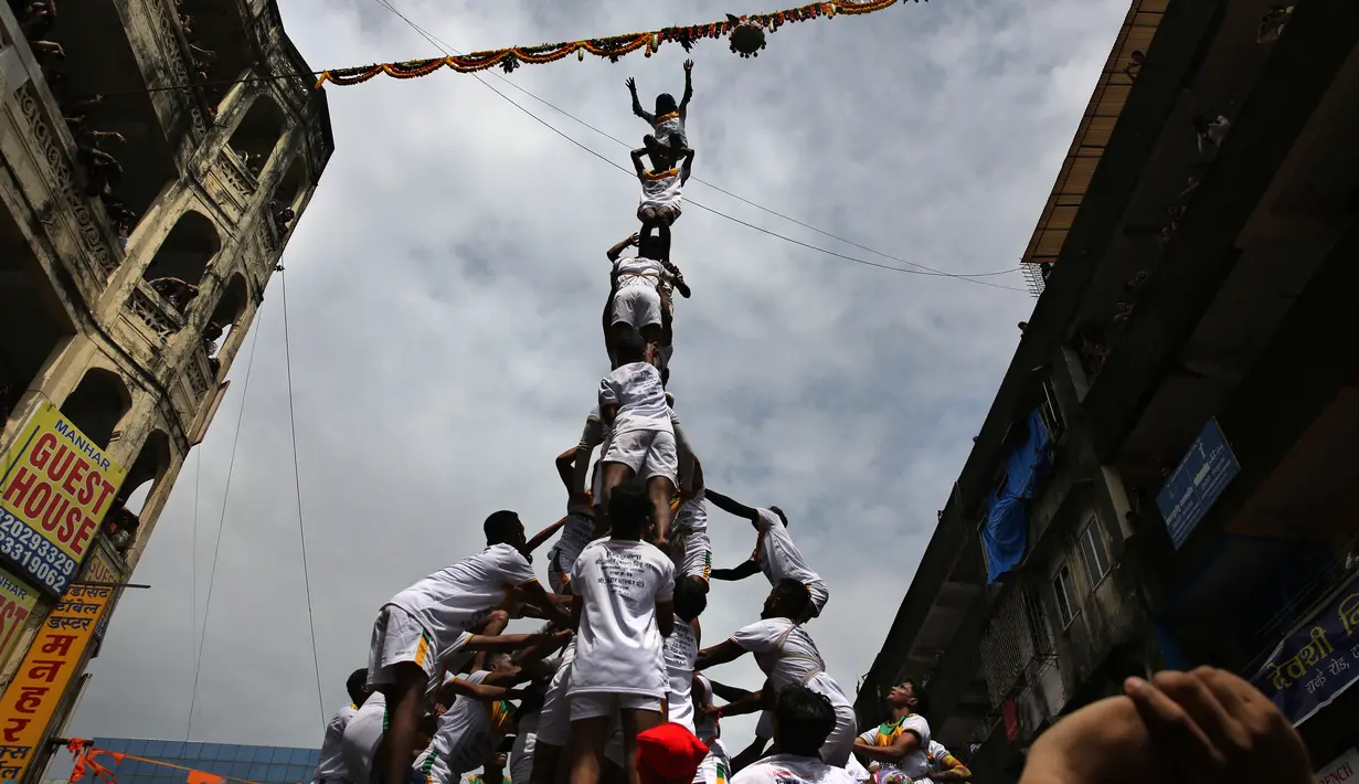 Pemuda India membentuk piramida manusia untuk memecahkan pot berisikan semacam susu dalam perayaan Festival Janmashtami di Mumbai, Senin (3/9). Festival Janmashtami dilakukan untuk menyambut kelahiran Dewa Krishna. (AP/Rafiq Maqbool)