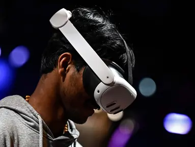 Seorang pria mencoba headset VR realitas campuran Meta Quest 3 selama pameran startup dan inovasi teknologi Vivatech, di pusat pameran Porte de Versailles di Paris, pada 22 Mei 2024. (JULIEN DE ROSA/AFP)