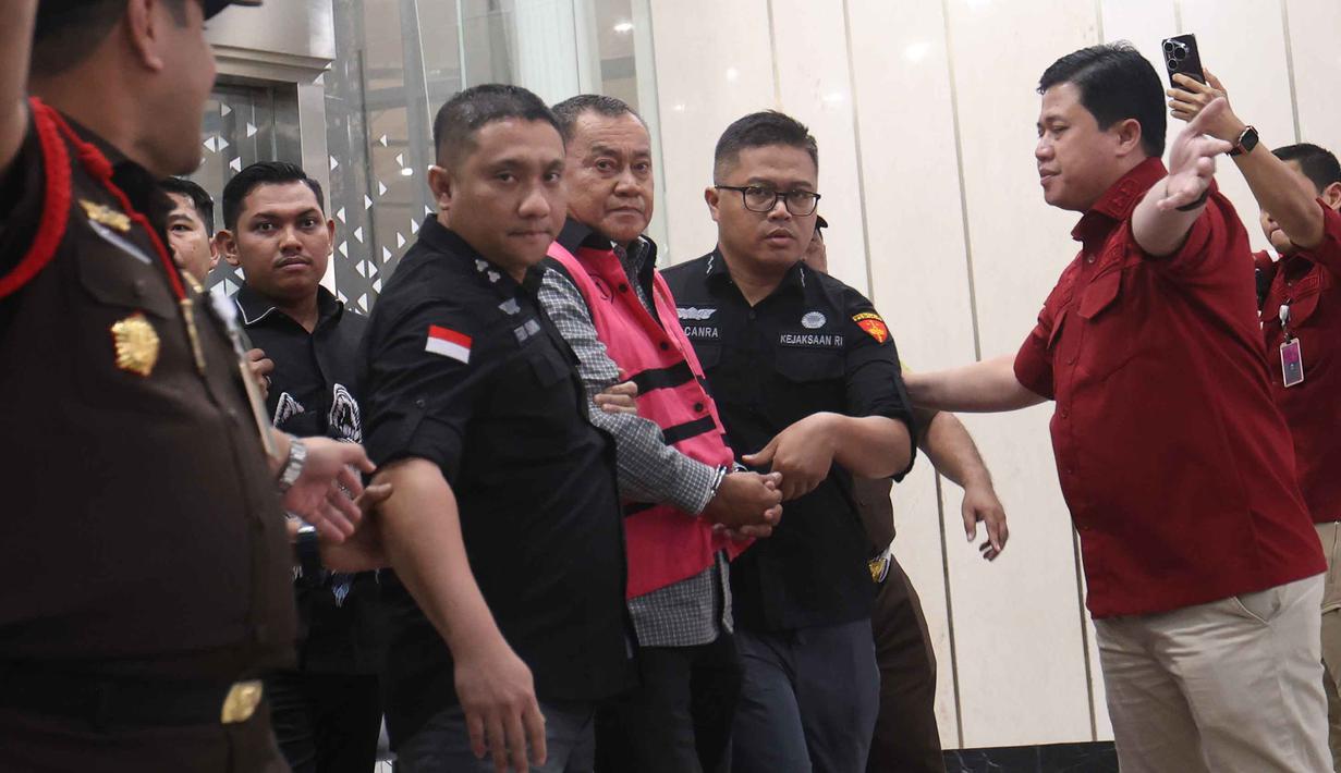 Mantan Wakil Kepala Badan Gizi Nasional (BGN), Lodewyk Pusung (mengenakan rompi tahanan), digiring menuju mobil tahanan usai menjalani pemeriksaan di Gedung Kejaksaan Agung RI, Jakarta, Rabu (3/6/2026). (Kapanlagi.com/Budy Santoso)