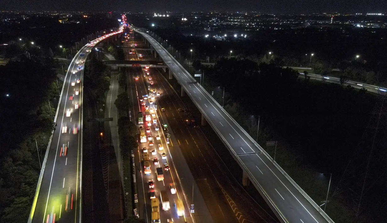 <p>Foto udara ini menunjukkan kendaraanroda empat tersendat saat melintasi Jalan Tol Jakarta - Cikampek di Karawang, Jawa Barat pada 28 April 2022. Lalu lintas di Jalan Tol Jakarta-Cikampek mengalami kemacetan panjang memasuki puncak arus mudik Lebaran 2022. (BAY ISMOYO / AFP)</p>
