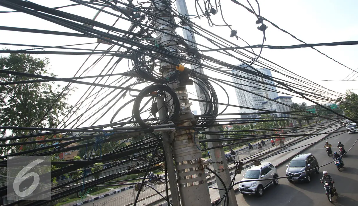 Instalasi kabel saling bersinggungan di tiang Jalan Gunung Sahari, Jakarta, Rabu (13/7). Kurangnya penataan membuat instalasi kabel di Ibu Kota terlihat semrawut dan mengganggu pemandangan. (Liputan6.com/Immanuel Antonius)