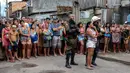 Sejumlah wargaberkerumun menyaksikan lokasi penembakan massal di sebuah bar di kota Belm, negara bagian utara Par, Brazil, Minggu (19/5). Hampir semua korban tewas mengalami luka tembak di bagian kepala, lapor situs web G1. (Claudio Pinheiro/Agencia Panamazonica/AFP)