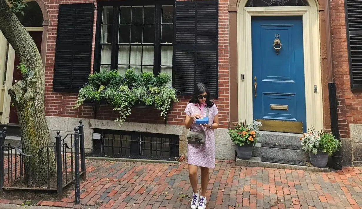 Gayanya ini dilengkapi secara kasual dengan sneakers putih, sunglasses, dan sling bag hijau. Foto: Instagram.