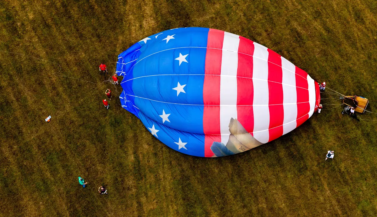 Awak darat memompa balon udara pada New Jersey Lottery Festival of Ballooning di Bandara Solberg, Readington, New Jersey, Amerika Serikat, 29 Juli 2022. Festival yang berlangsung hingga 31 Juli ini akan menampilkan sebanyak 100 balon. (AP Photo/Julia Nikhinson)