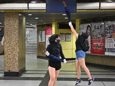 Sejumlah demonstran bertopeng merusak Stasiun MTR Wong Tai Sin di Distrik Kowloon, Hong Kong, Senin (7/10/2019). Demonstran bertopeng merusak beberapa stasiun MTR di Hong Kong. (Philip FONG/AFP)
