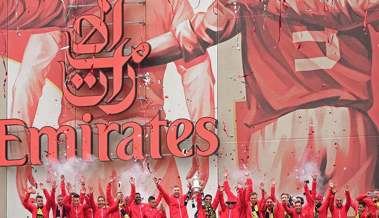 Para pemain merayakan sukses Arsenal meraih gelar Piala FA. Mereka konvoi keliling kota London untuk menyapa para fans. (AFP/Leon Neal)