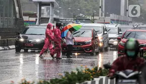 Pejalan kaki yang menggunakan payung saat hujan deras menyeberang jalan di kawasan Thamrin, Jakarta, Rabu (23/11/2022). Sejak Oktober, DKI Jakarta mulai memasuki musim penghujan yang sudah masuk ke dalam tahap ekstrem. (Liputan6.com/Faizal Fanani)