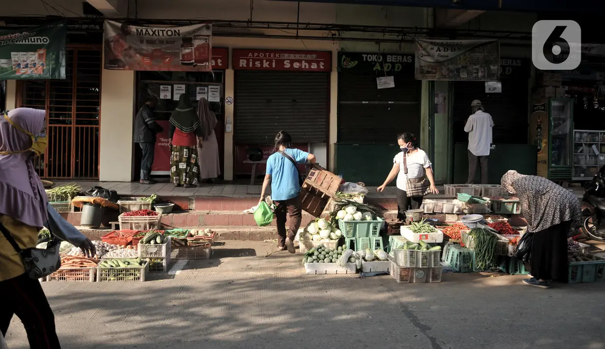 Aktivitas perdagangan dengan menerapkan physical distancing  di halaman Pasar Perumnas Klender, Jakarta, Kamis (18/6/2020). Selain sistem ganjil genap kios, pengelola pasar menerapkan physical distancing antarlapak untuk mencegah penularan COVID-19. (merdeka.com/Iqbal S. Nugroho)