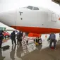 Mekanik maskapai Jeju Air mengikat sebuah pesawat di landasan saat Topan Hinnamnor bergerak menuju Semenanjung Korea di Bandara Internasional Gimpo di Seoul, Korea Selatan, Senin (5/9/2022). Hembusan angin dan hujan lebat dari Topan Hinnamnor diperkirakan mencapai hingga 290 kilometer (180 mil) per jam. (Korea Pool/Yonhap via AP)