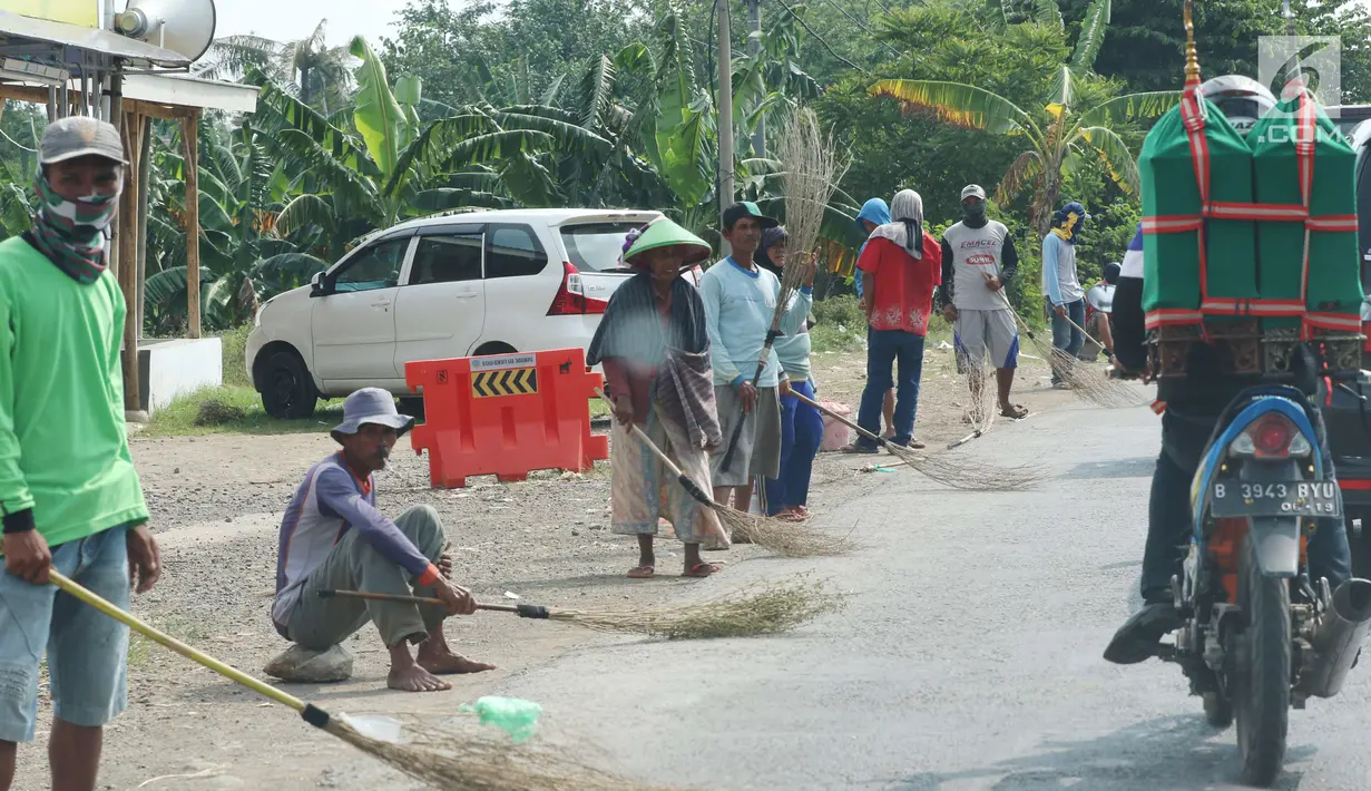 Sejumlah penyapu koin kali Sewo menunggu di sepanjang pinggir jalan, Subang, Jawa Barat, Sabtu (7/1). Konon keberadaan penyapu uang logam di sekitar jembatan sewo sudah lama ada dan aktifitasnya berlangsung tiap hari. (Liputan6.com/Helmi Afandi)