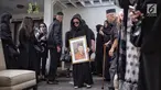 Adik Olla Ramlan, Cynthia Ramlan membawa foto sang ayahanda, Muhammad Ramlan di rumah duka kawasan Pondok Indah, Jakarta Selatan, Selasa (5/6). Ayahanda dari Olla Ramlan itu menghembuskan napas terakhirnya di usia 72 tahun. (Liputan6.com/Faizal Fanani)
