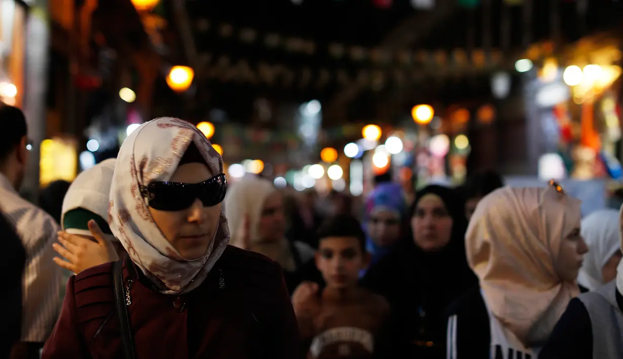 Sejumlah warga berjalan di pasar Hamadiyah, atau souk dalam bahasa Arab, yang diberi nama setelah Sultan ke-34 Kekaisaran Ottoman Abdul Hamid II, di Kota Tua Damaskus, Suriah, (14/7). (AP Photo / Hassan Ammar)