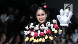 Artis Sandra Dewi berjalan di 'catwalk' mengenakan busana kolaborasi antara Disney dan Matahari pada Jakarta Fashion Week 2019 di Senayan City, Selasa (23/10). Sandra Dewi mengenakan busana dengan ornamen boneka Mickey Mouse. (Liputan6.com/Faizal Fanani)