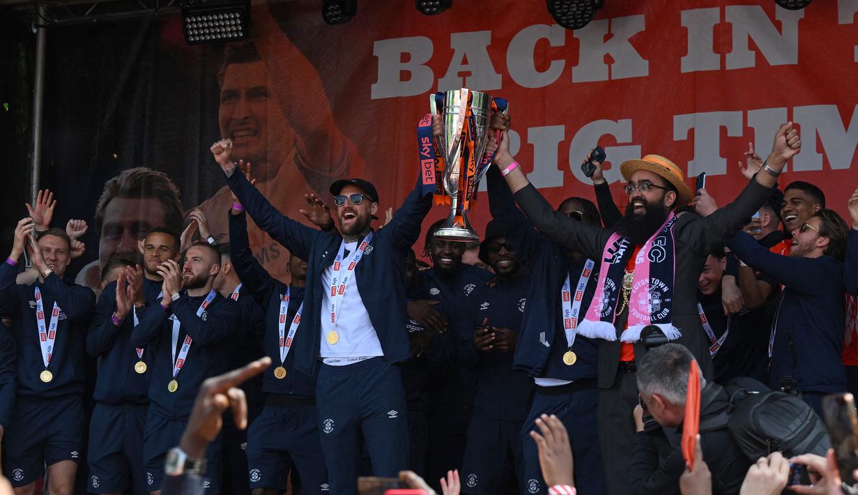 Pemain Luton Town, Sonny Bradley (kiri) bersama Walikota Luton, Mohammed Yaqub Hanif mengangkat trofi ketika parade kemenangan di Luton, Inggris pada Senin (29/05/2023) waktu setempat. The Hatters sukses menyegel tiket promosi ke Liga Inggris 2023/2024 setelah memenangkan laga play-off divisi Championship melawan Covetry City 6-5 melalui adu penalti di Wembley, Sabtu (27/5/2023). (AFP/Daniel Leal)