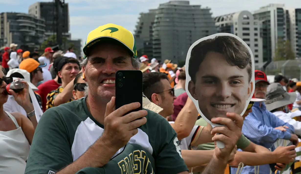 Seorang fan memegang topeng pembalap McLaren, Oscar Piastri dalam sesi latihan bebas Formula 1 GP Australia 2025 di Sirkuit Albert Park, Melbourne, Australia pada Jumat (14/03/2025). (AFP/Saeed Khan)