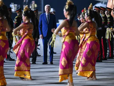 Presiden Amerika Serikat (AS) Joe Biden disambut oleh tarian khas Bali saat turun dari pesawat kepresidenan AS, Air Force One setibanya di Bandara I Gusti Ngurah Rai Bali, Minggu (13/11/2022). Satu per satu tamu undangan perhelatan acara puncak Konferensi Tingkat Tinggi (KTT) G20 mulai berdatangan. (Photo by SAUL LOEB / AFP)