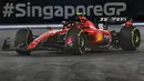 Pembalap tim Scuderia Ferrari, Carlos Sainz memacu mobilnya dalam balapan F1 GP Singapura 2023 di Marina Bay Street Circuit, Singapura, Minggu (17/9/2023) malam WIB. (AFP/Roslan Rahman)