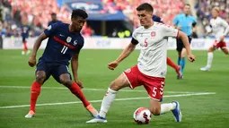 Bek timnas Denmark Joakim Maehle (kanan) berebut bola dengan penyerang Prancis Kingsley Coman pada laga perdana Grup A UEFA Nations League di Stade de France, Paris, Prancis, Sabtu(4/6/2022) dini hari WIB. Prancis harus rela menelan kekalahan 1-2 dari tamunya Denmark. (Franck FIFE / AFP)