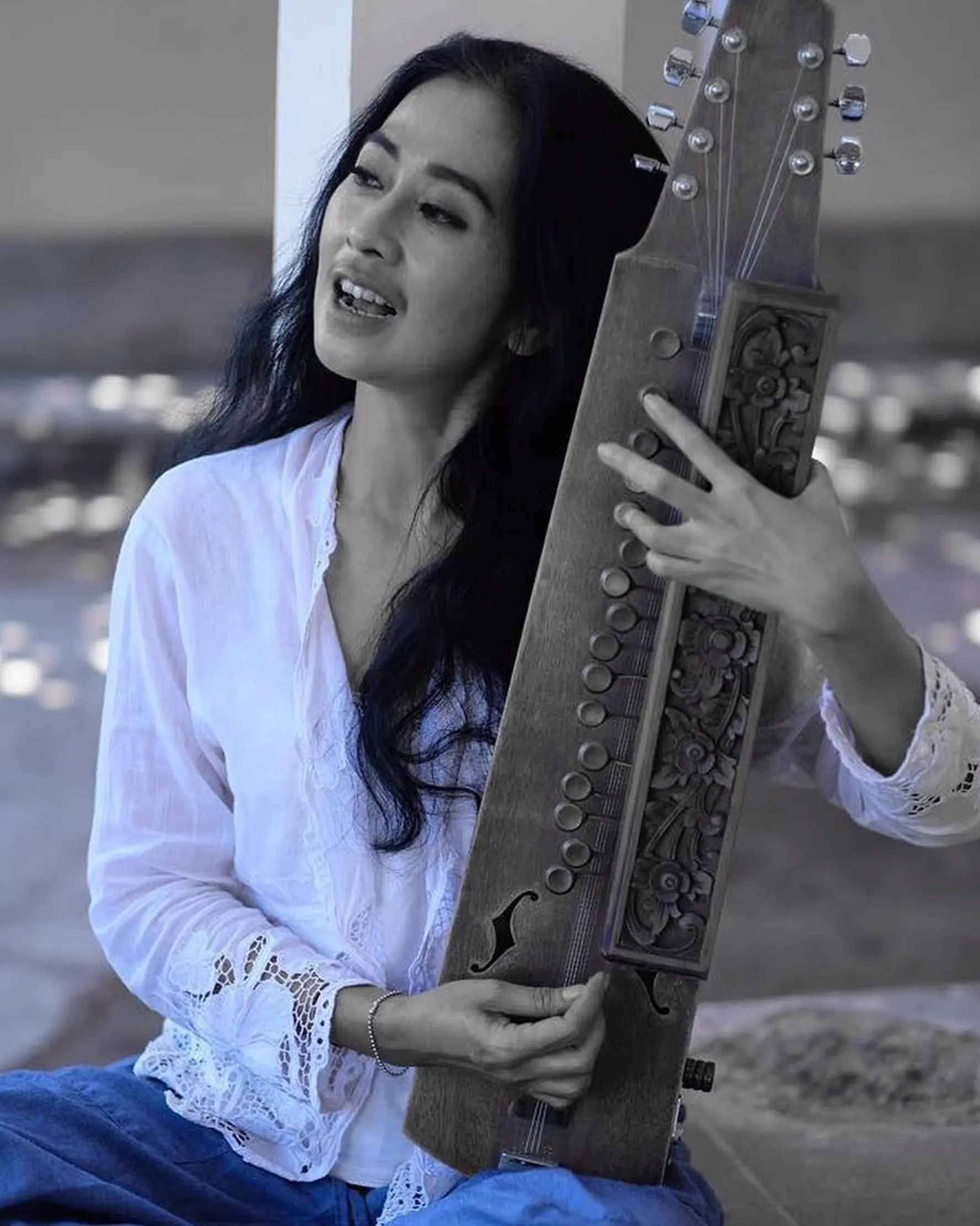 Aktris Ayu Laksmi berpose sambil memegang alat musik. Dalam dunia musik, Ayu Laksmi membentuk grup musik bernama Svara Semesta yang sering tampil di Bali. (instagram/ayulaksmibali)